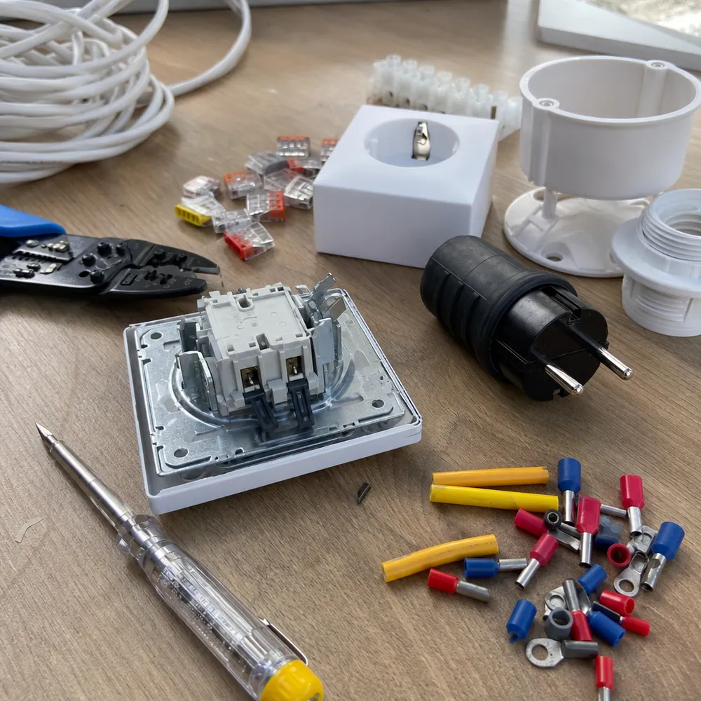 Alat i materijal za elektroinstalacije — žice, utičnica, konektori i odvijač na radnom stolu električara u Novom Sadu